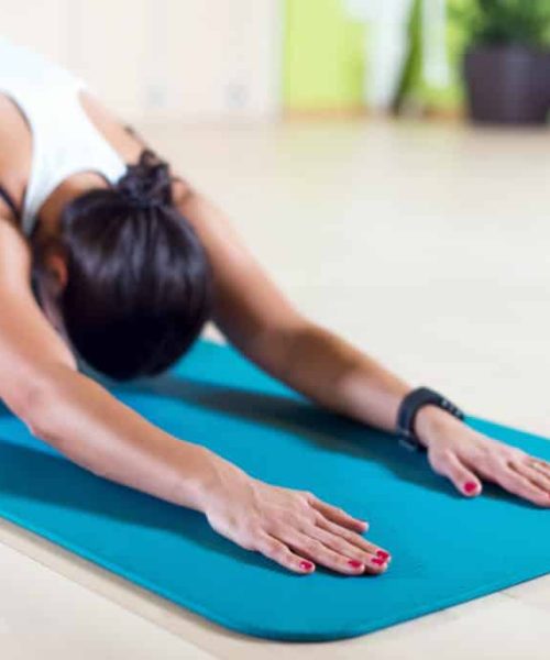 Fit woman doing stretching pilates exercises in fitness studio